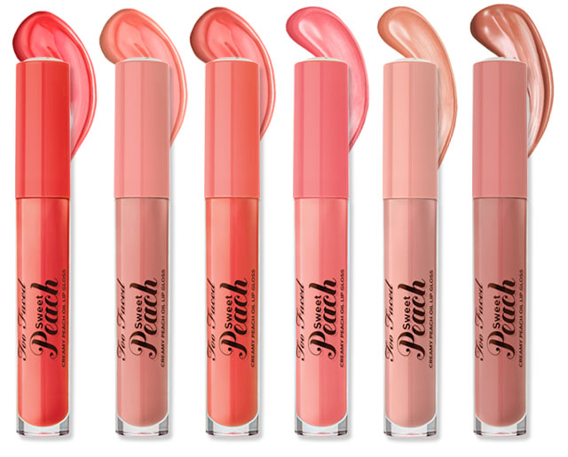 Too Faced Sweet Peach Oil Lip Glosses are lined up horizontally displaying all six shades – peachy pinks, corals and nudes.